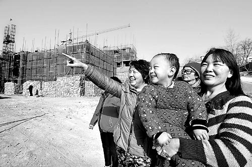 12月10日,洛阳市高新区孙旗屯乡东沙坡村几位村民在观看新社区建设